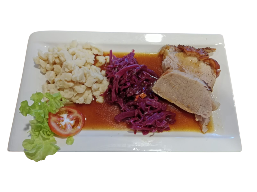 Plate of sliced meat with red cabbage, cauliflower, lettuce, and tomato garnish.