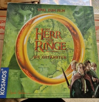 Board game box featuring "Herr der Ringe" with a green map and characters from the story.