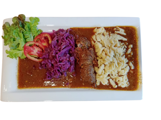 Plate of food featuring stuffed cabbage, red cabbage, tomatoes, and pasta in sauce.